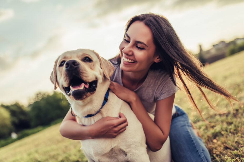 young woman with labrador outdoors.