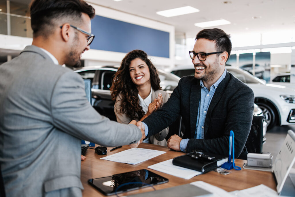 Middle age couple choosing and buying car at car showroom.